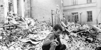 Un niño sentado sobre las ruinas de un edificio bombardeado durante el sitio de Varsovia.