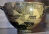 La inscripción en la copa de Néstor, grabada tras la cocción con el raspado de la superficie, se compone de tres líneas, escritas de derecha a izquierda, y usa la variedad eubea temprana del alfabeto para plasmar con ella el dialecto jónico.