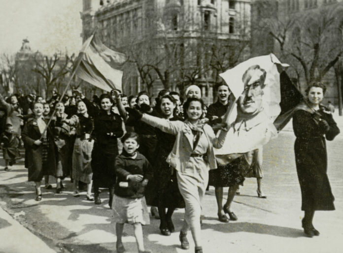 201 - Principal Un grupo de mujeres enarbola un retrato de Franco durante las celebraciones callejeras en Madrid por el fin de la guerra civil española, en 1939.
