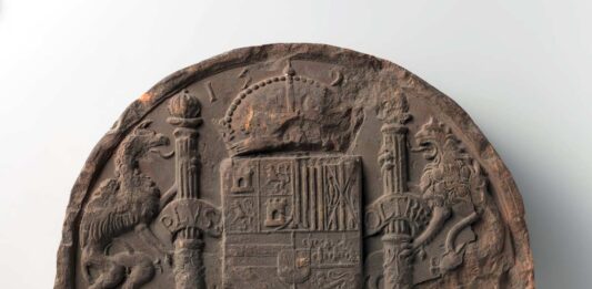 Fragmento de piedra con el escudo español y el lema Plus Ultra